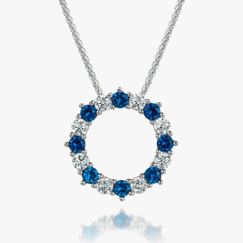 circle outline claw set pendant set with alternating blue and white stones